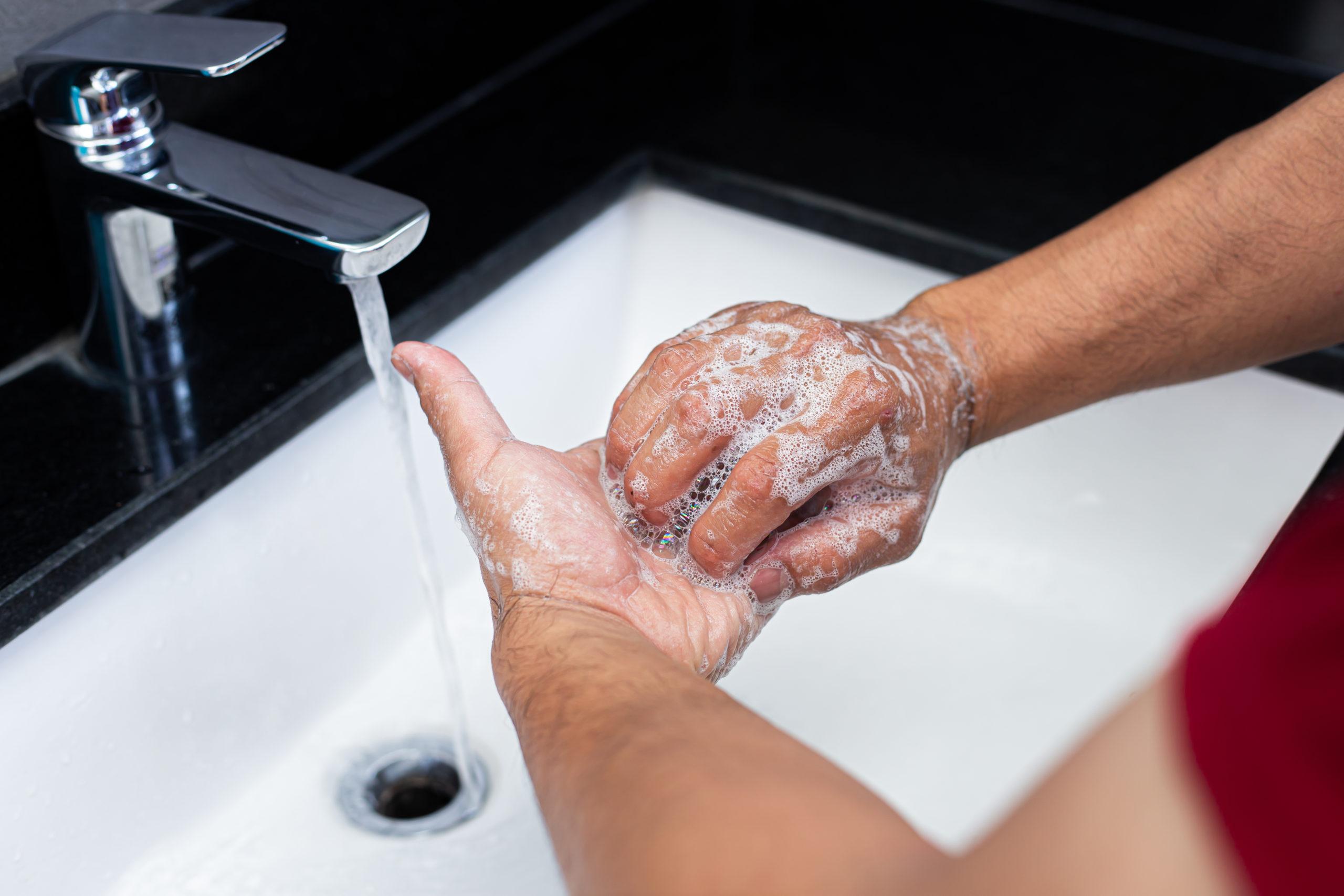 Люди моющие руки в раковине